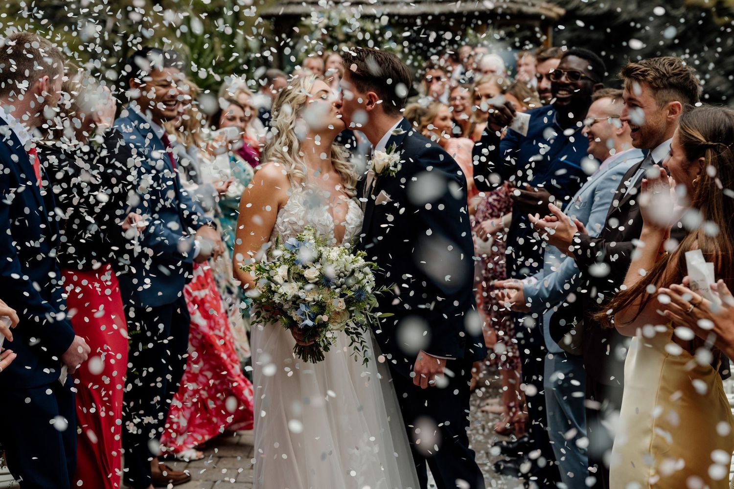 Joyful wedding celebration with confetti being thrown in a candid moment.