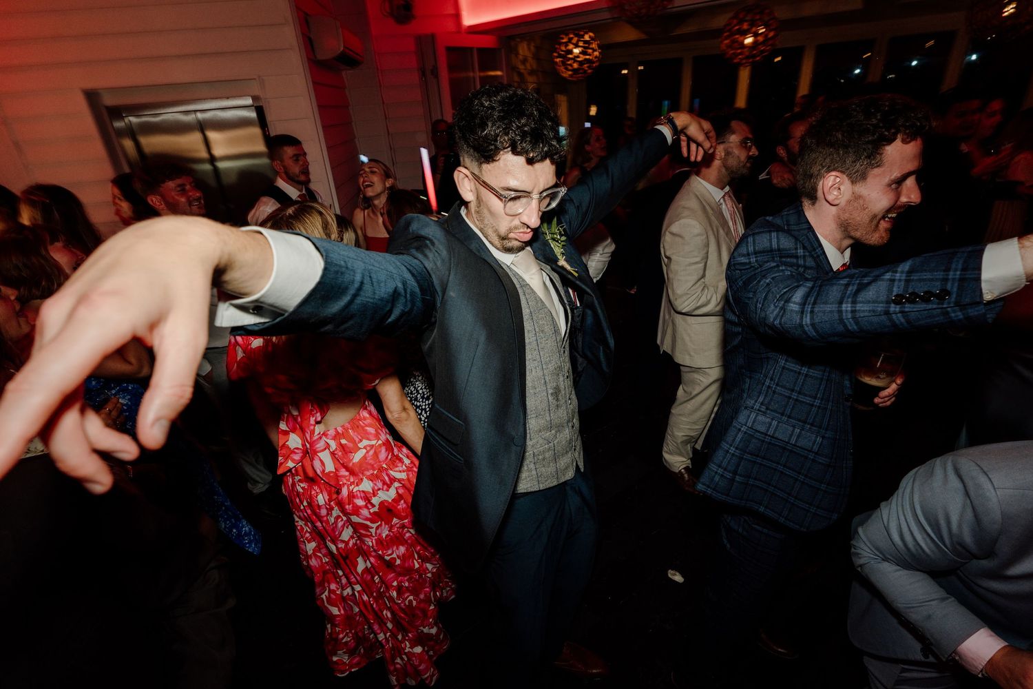 Lively dance party scene with guests enjoying themselves at a wedding reception.