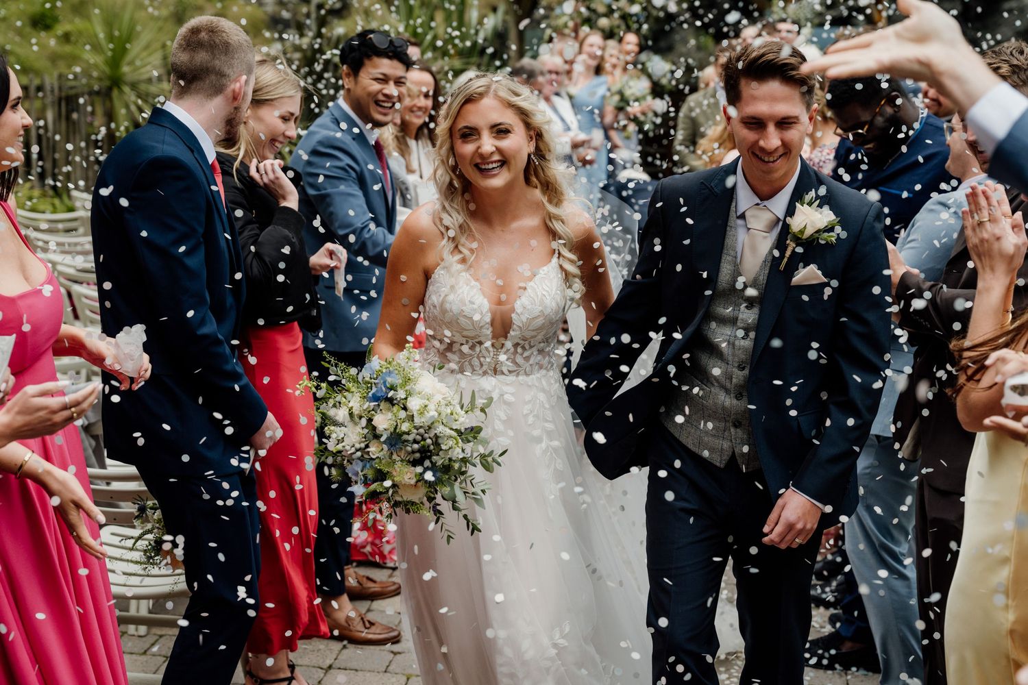 Joyful wedding celebration with confetti being thrown at the newlyweds.