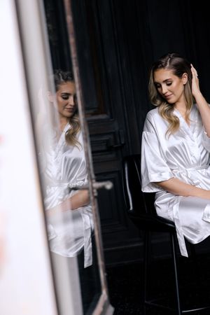 Series of artistic portrait shots showing a silhouette in a white silk robe against a dark background.