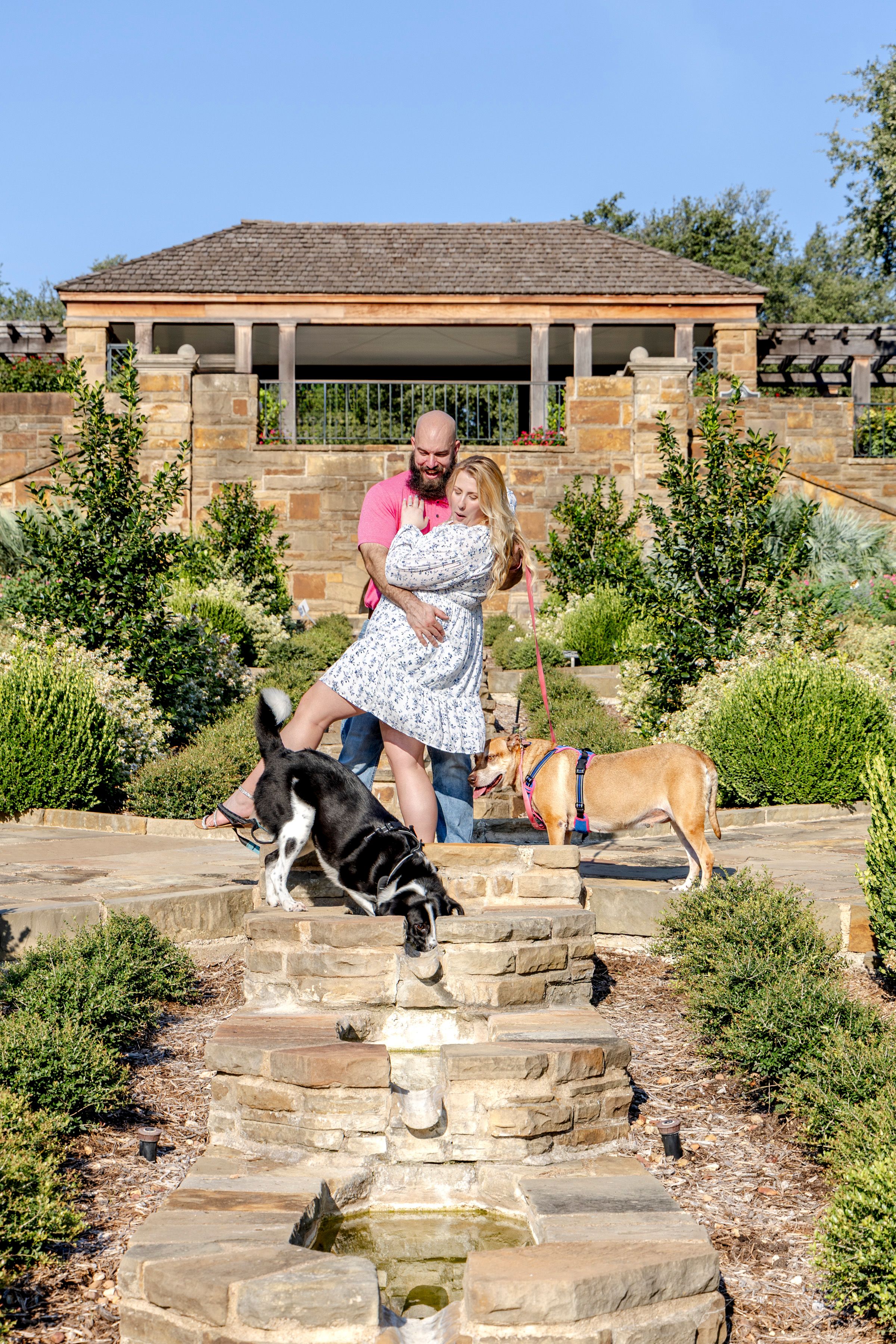 Couple laughing as their dog jumps into the pond at Fort Worth Botanical Gardens