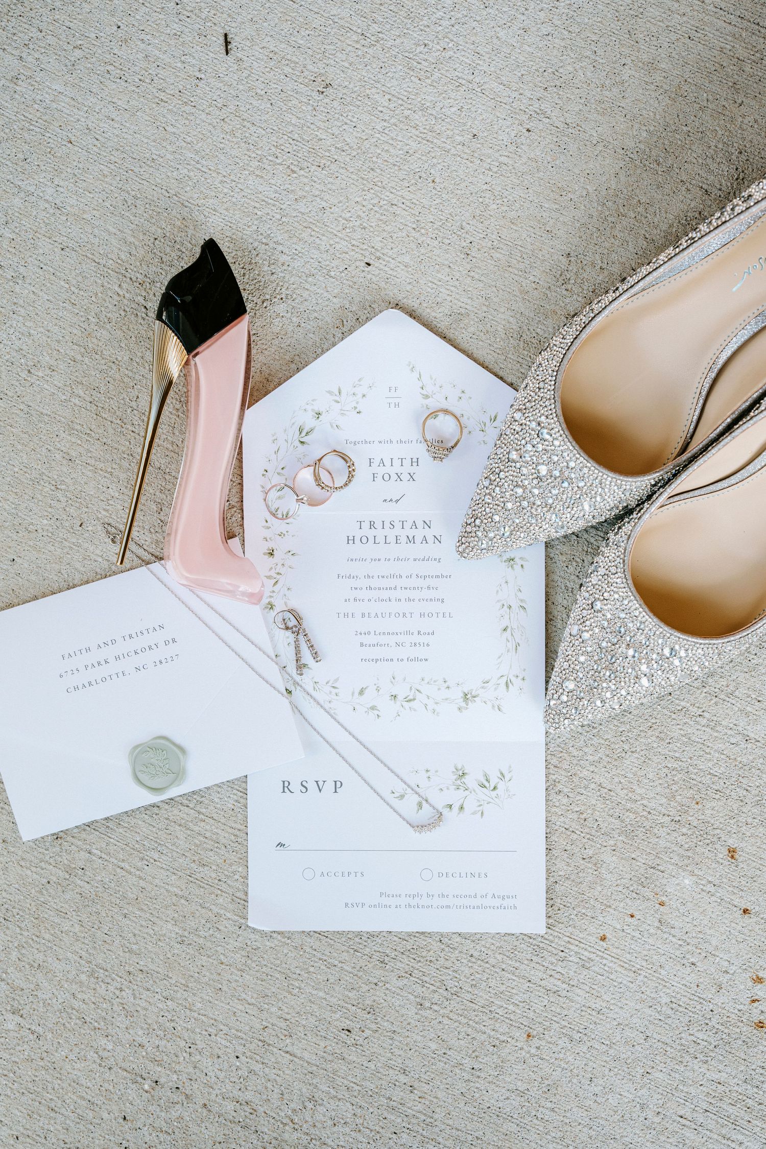 Elegant wedding invitation suite in blush pink and white with matching envelopes and calligraphy details.