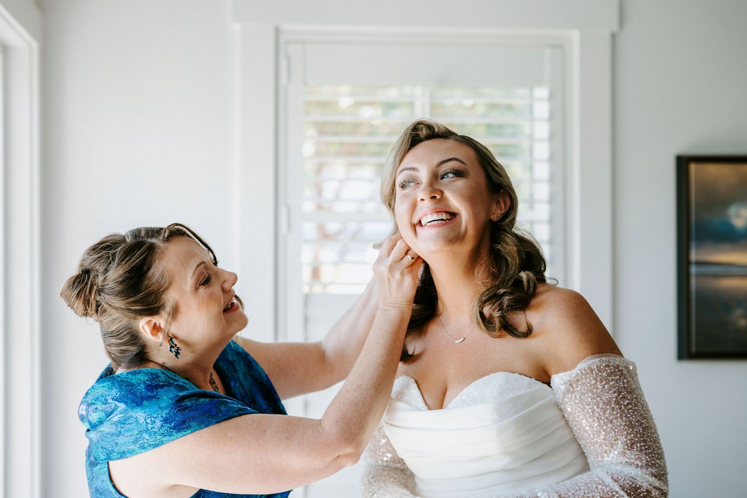 Capturing emotional moments during wedding day preparations in an elegantly lit room.