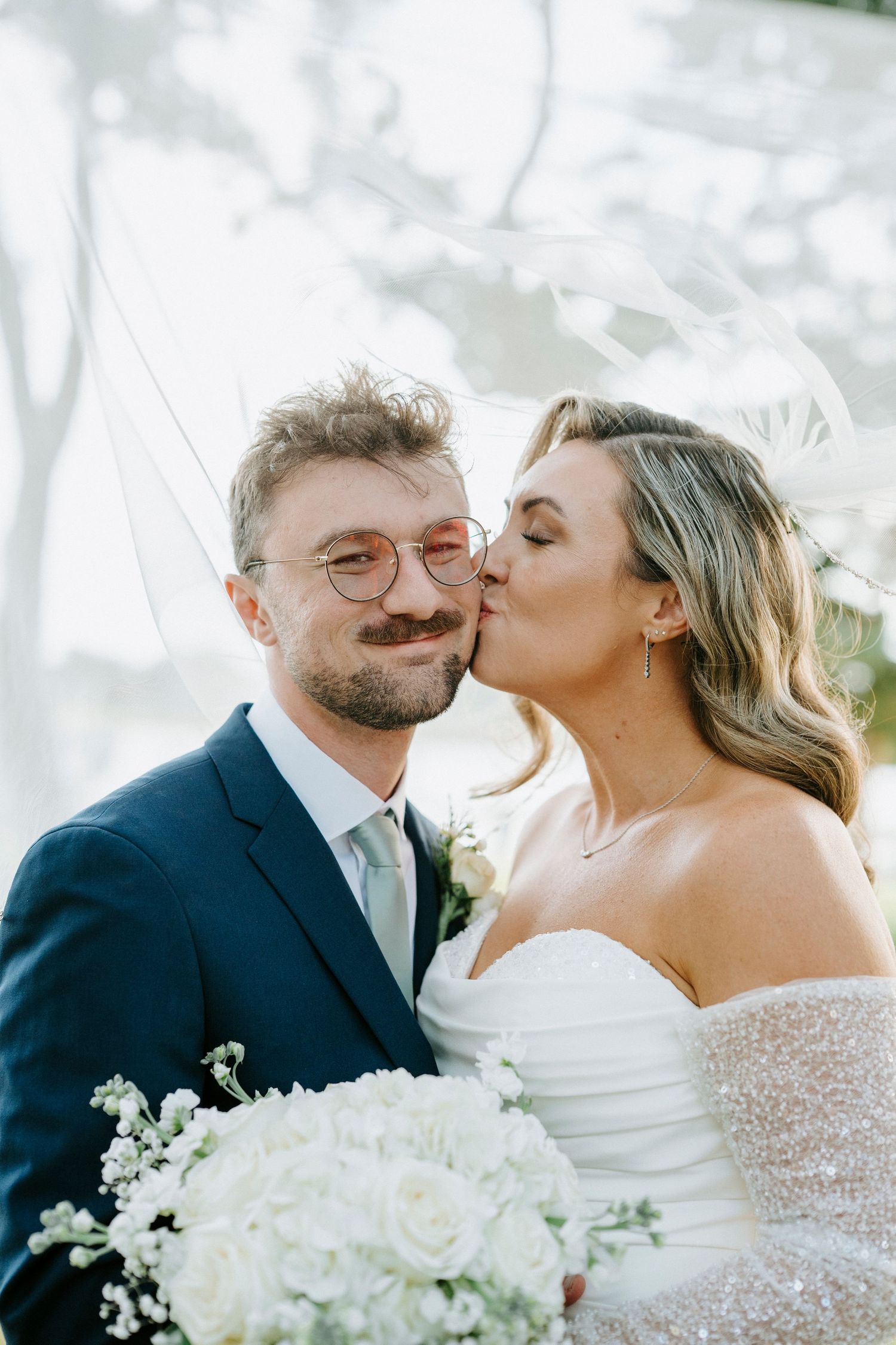 Series of romantic wedding photos showing affectionate moments between couple with white floral bouquet.