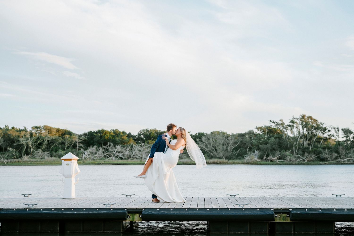 Panoramic view of a coastal wedding venue with water and palm trees in the background.