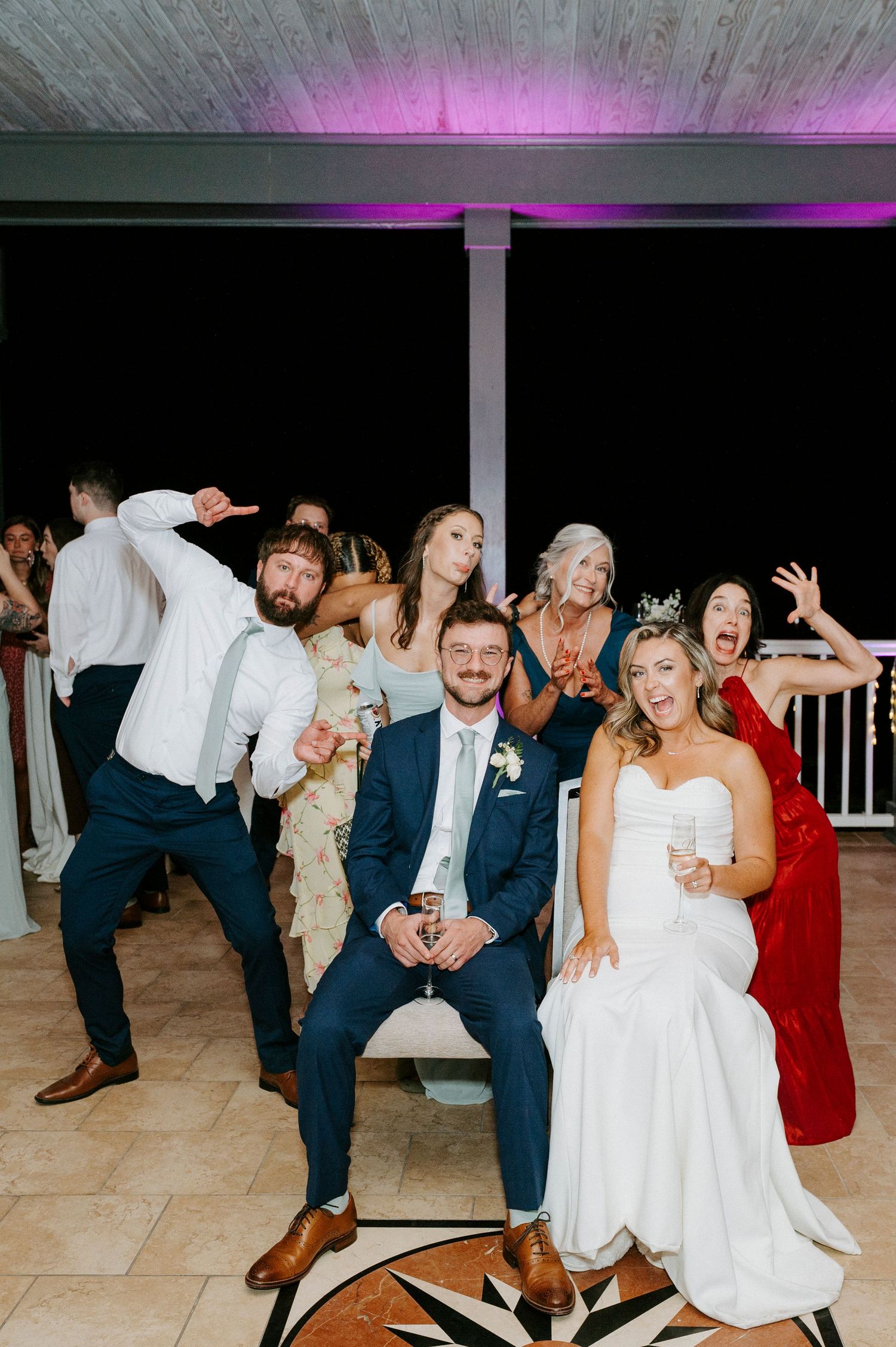 Wedding reception dance floor filled with guests dancing and celebrating in festive atmosphere.