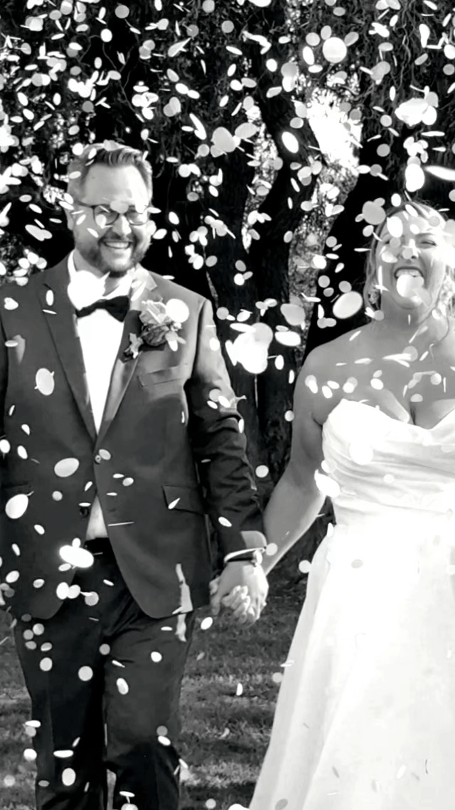 Bride and groom walking down the aisle under willow tree with confetti at West Avenue Cider House wedding in Hamilton Ontario