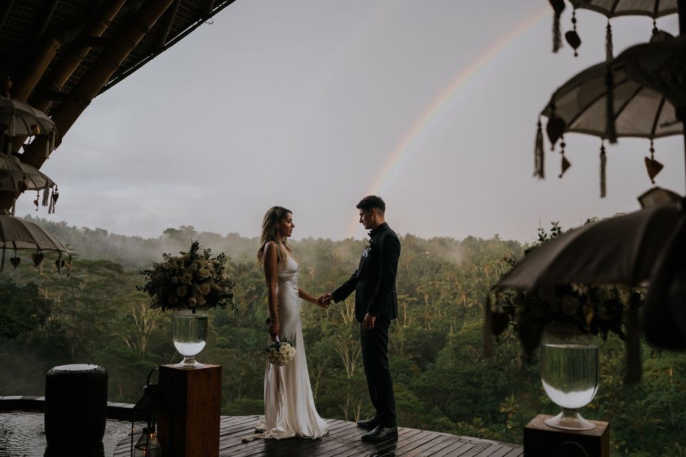 Romantic sunset wedding ceremony under wooden pavilion with mountain views.