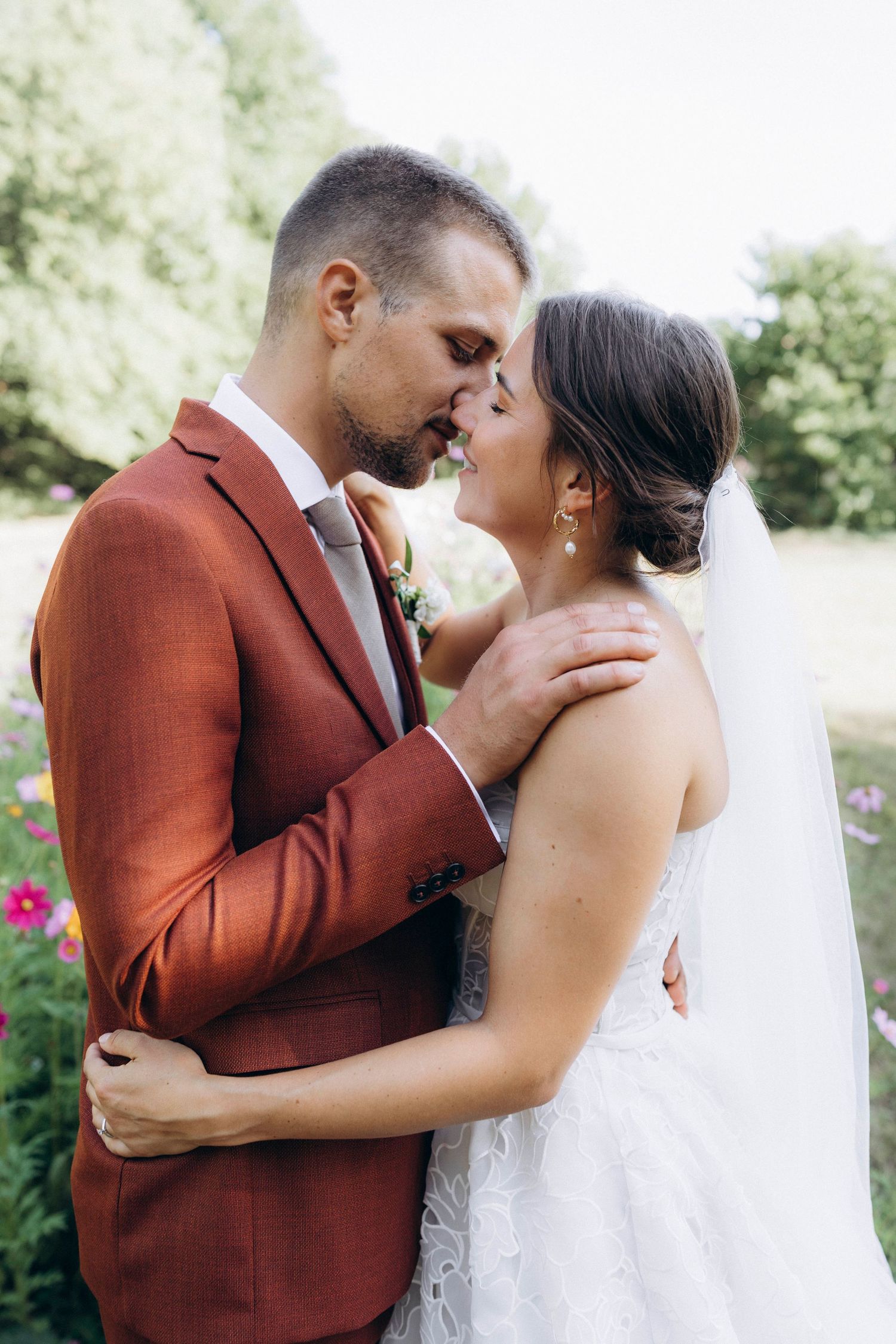 A tender autumn embrace captured during a wedding photoshoot with fall foliage.