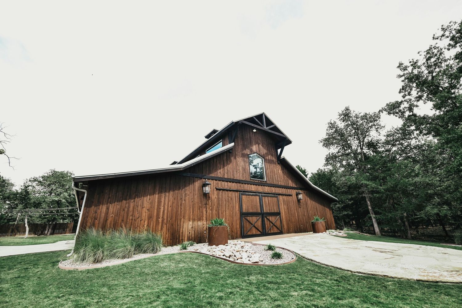 Chic rustic-modern barn wedding venue surrounded by trees taken by april pinto photography