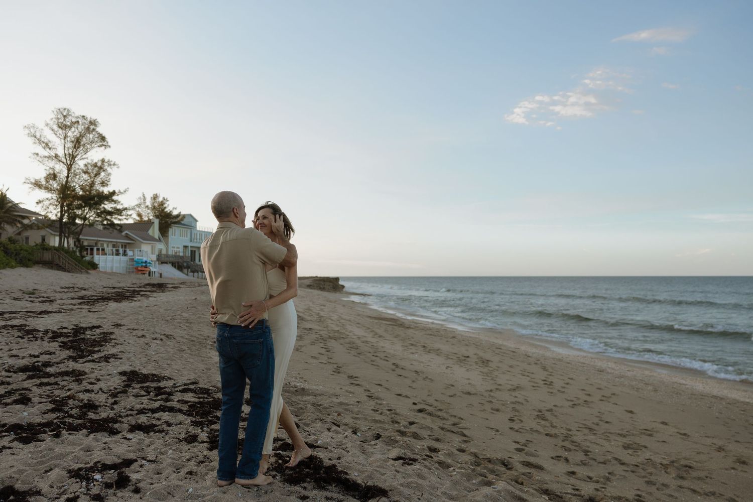 Couple enjoying a romantic stroll on a serene beach with ocean views.