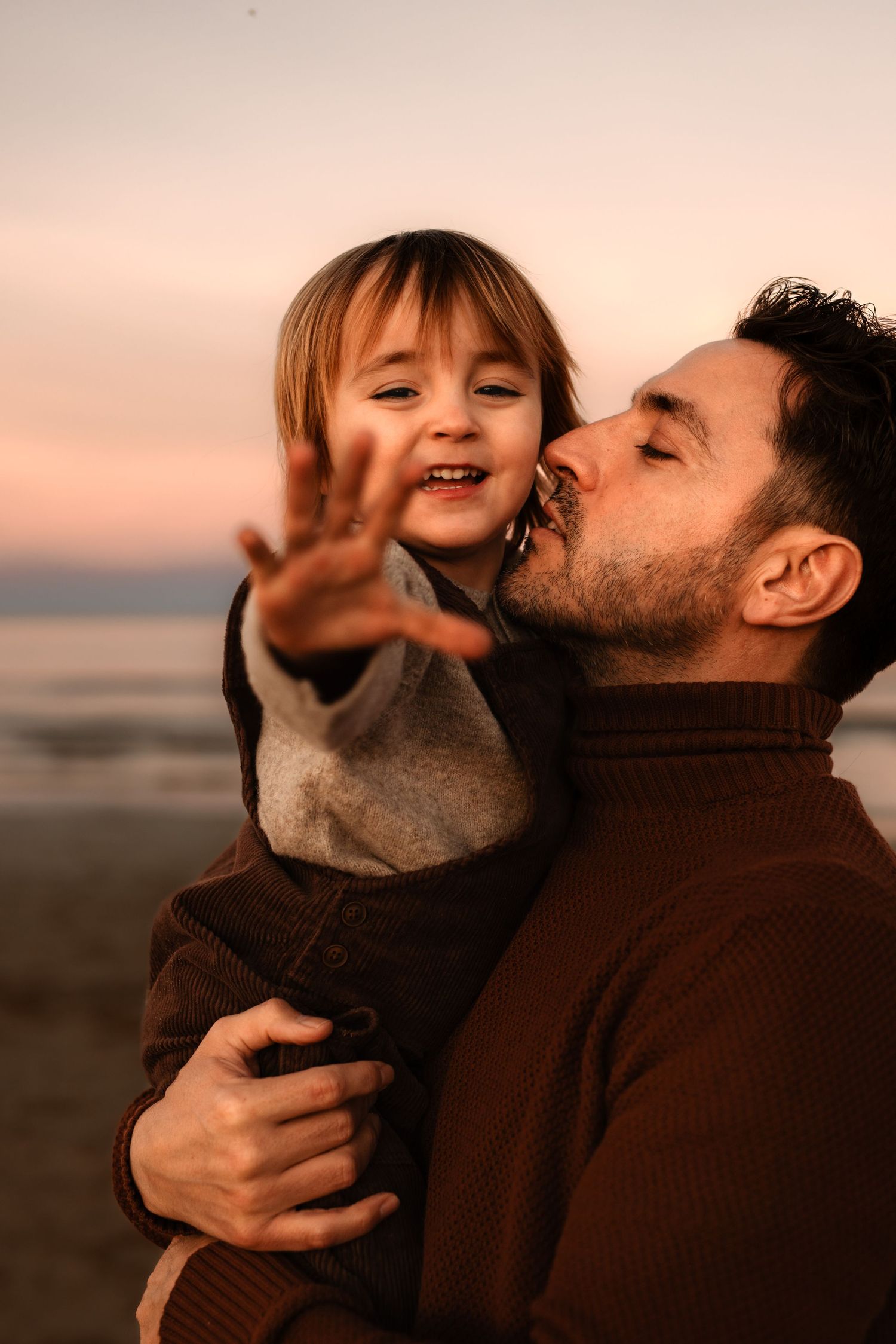 A heartwarming moment between father and child in Javea playing together during sunset, captured in warm tones. Javea photographer