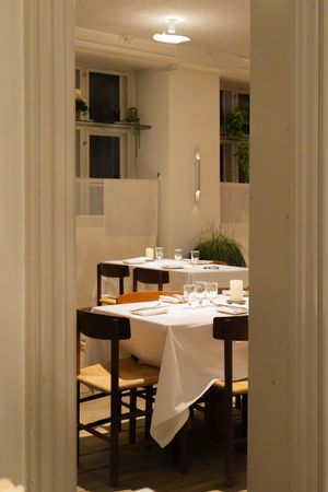 Elegant dining room with white-clothed tables and columns creating a sophisticated atmosphere.