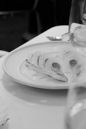Close-up of white ceramic plates with food remnants in black and white photography.