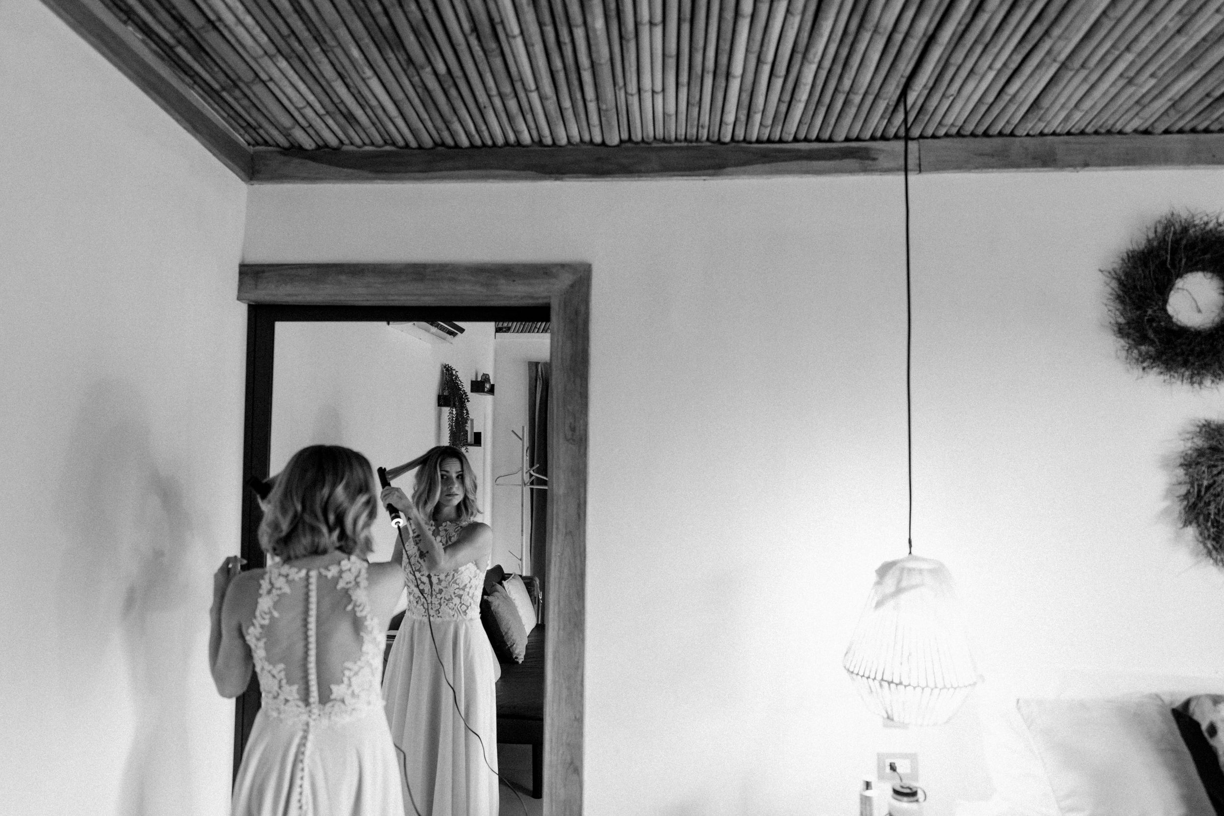 Black and white interior shot showing hanging decorative elements against bamboo ceiling.