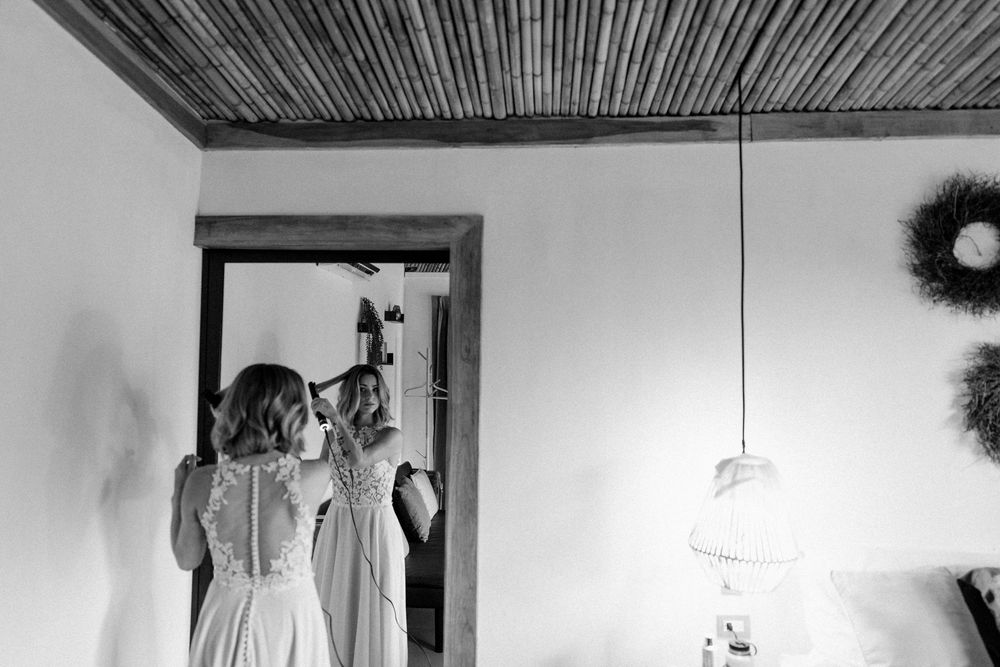 Black and white interior shot showing hanging decorative elements against bamboo ceiling.