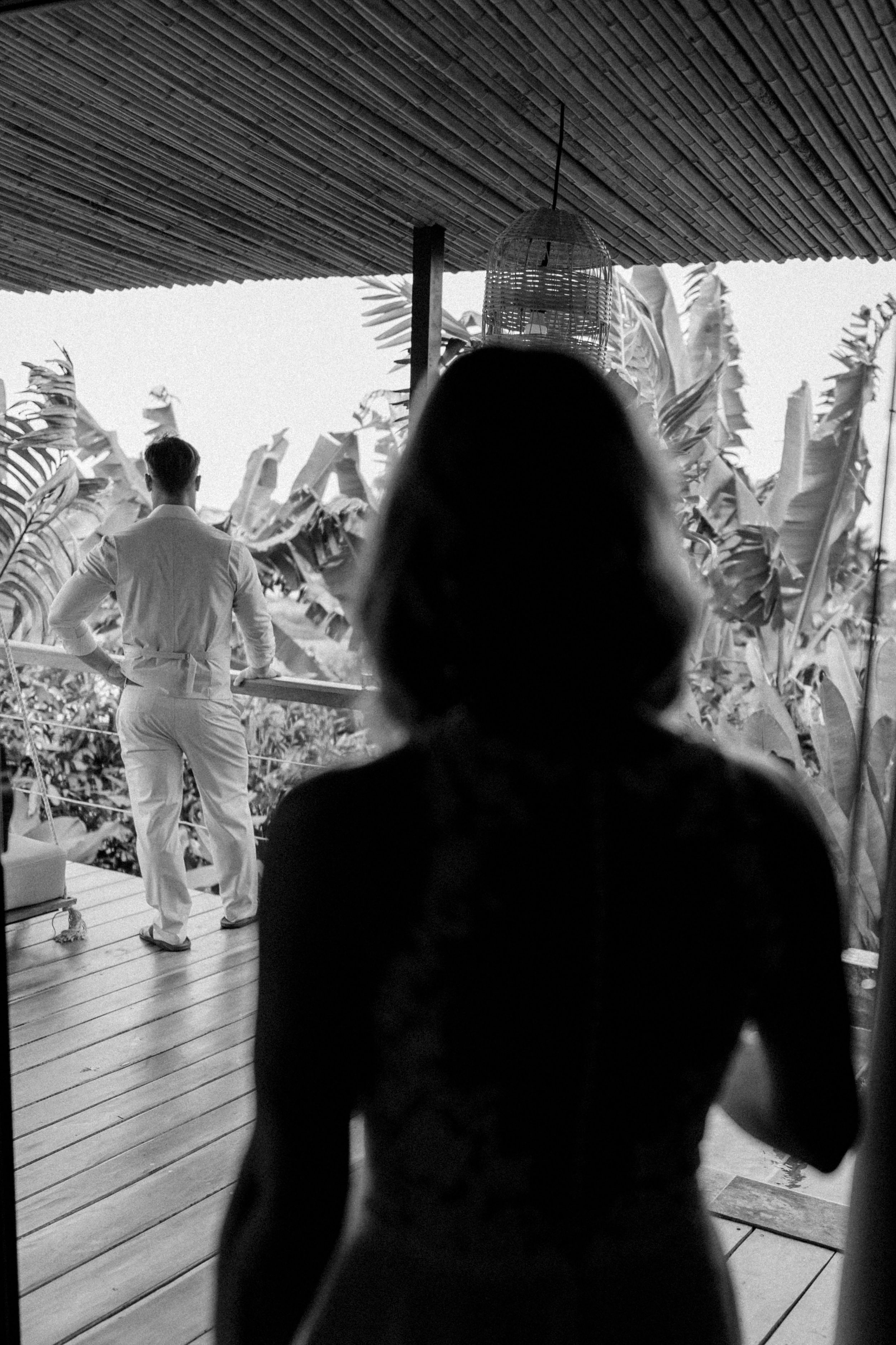 Black and white silhouettes dancing in a tropical setting with palm trees in the background.
