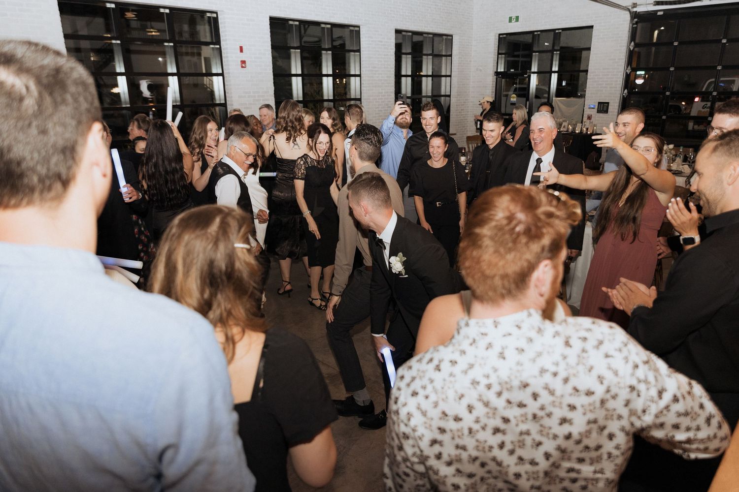 guests dance during party reception at Tire Shack Brewery night time flash photography