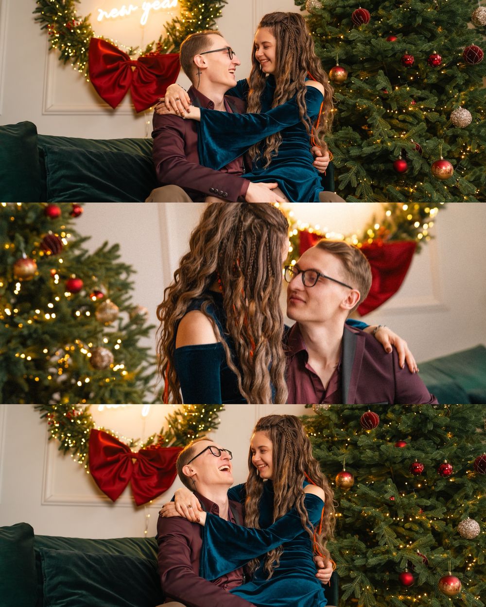 Romantic couple embracing in front of decorated Christmas tree with festive wreath and lights.