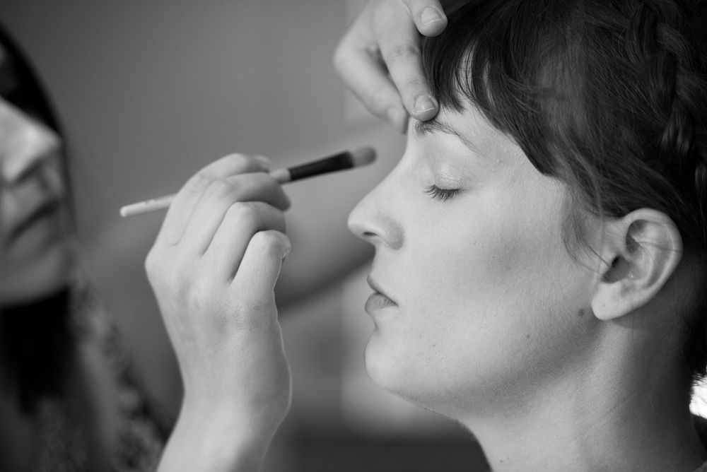 Side profile view showing detailed makeup application technique.