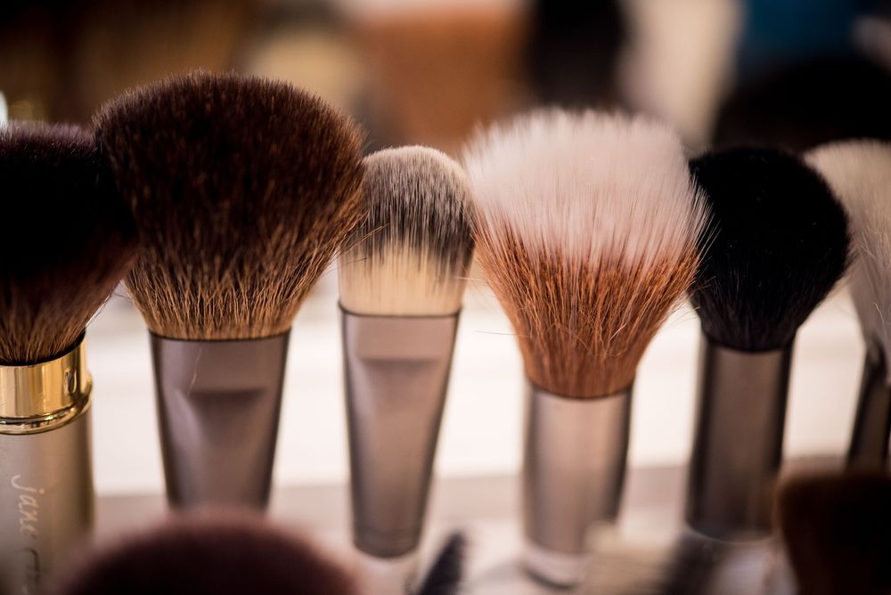 Collection of professional makeup brushes arranged together showing different bristle types and sizes.