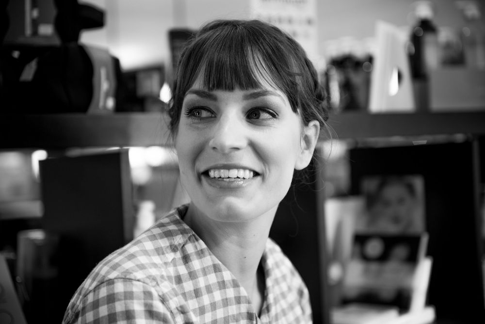 A black and white portrait showing a cheerful expression and checkered shirt.