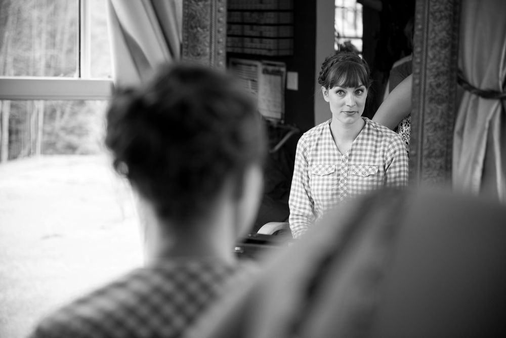 A candid black and white indoor photograph showing people in conversation.
