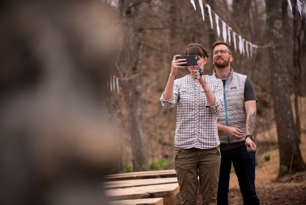 White triangle bunting decorates a wooded outdoor venue during a casual spring celebration.