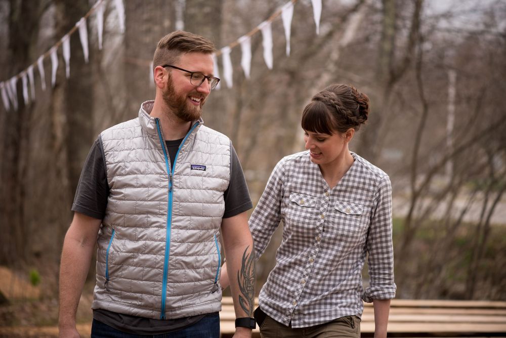 Casual outdoor gathering with white triangle bunting decorations and natural woodland backdrop.