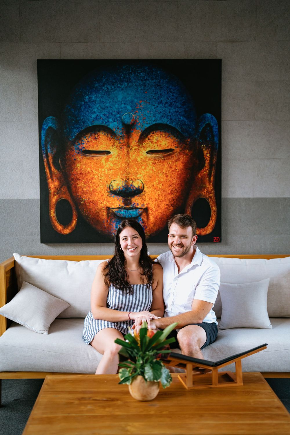 Interior lounge setting with vibrant Buddha artwork and modern furnishings.