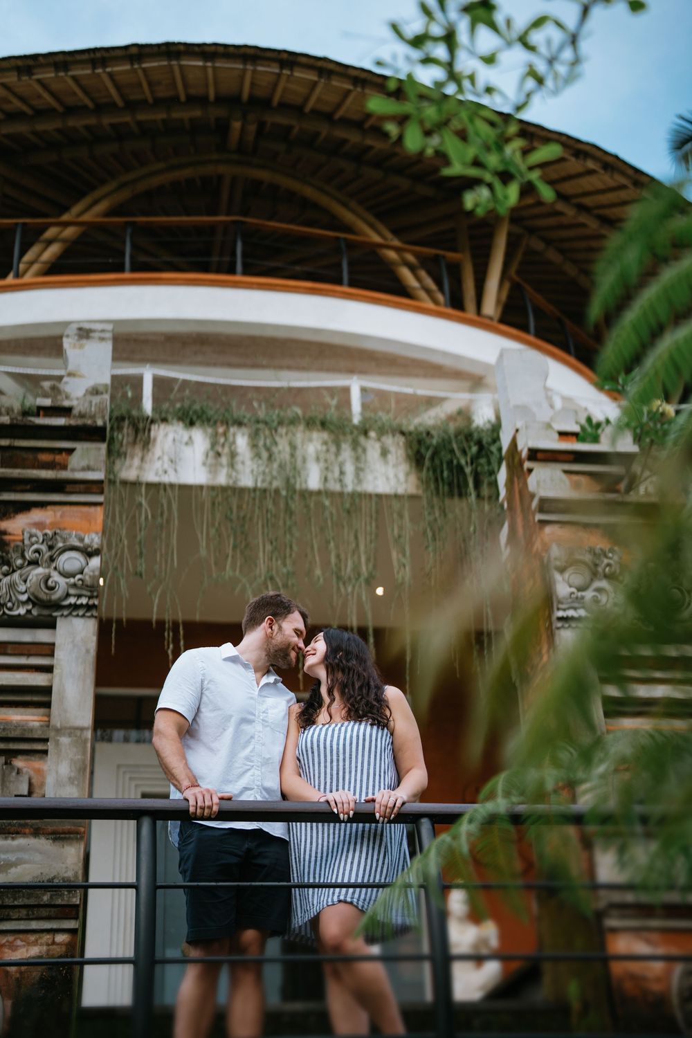 A romantic scene unfolds on a covered patio with wooden beams and natural lighting.