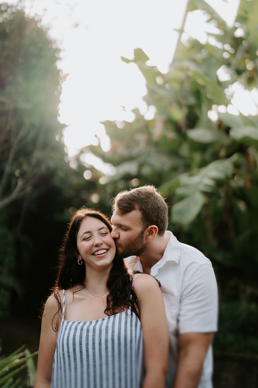 A romantic sunset moment captured among tropical foliage and golden sunlight.