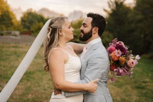 A couple shares romantic moments in an outdoor garden setting during their wedding photoshoot at sunset.