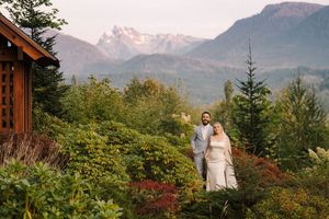 A scenic mountain wedding photoshoot with autumn foliage and majestic peaks in the background.