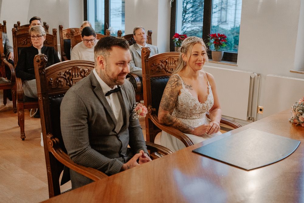 A series of candid moments during a wedding reception showing guests seated at wooden tables in a bright indoor venue.
