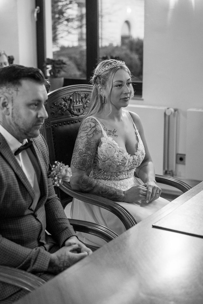 Black and white wedding photo showing couple sitting together in car after ceremony.