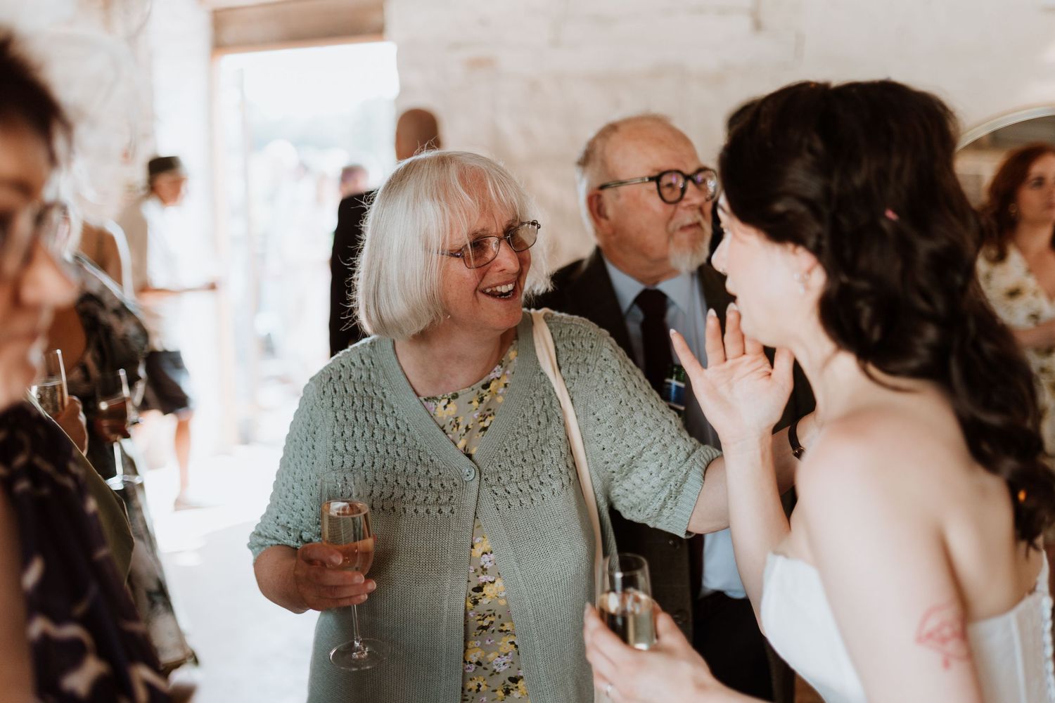 Candid moments of a wedding day showing embracing and celebrating guests at The Courtyard Venue, Oswestry