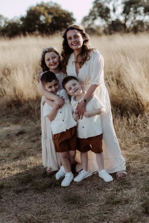 Candid moments of laughter and joy captured in a golden field during a family photoshoot.