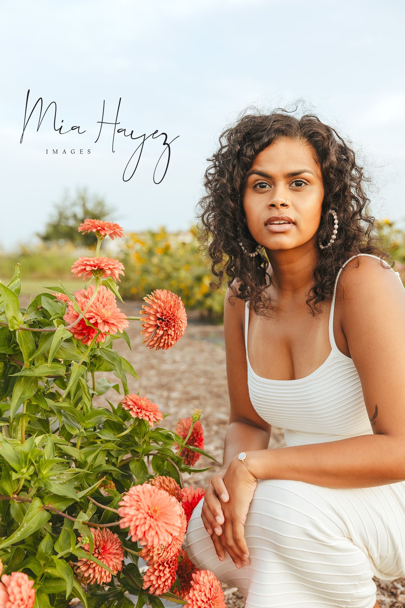Portrait series in a garden with coral dahlias and natural lighting.