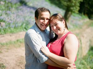 A couple shares an intimate moment together while posing outdoors in a natural setting.