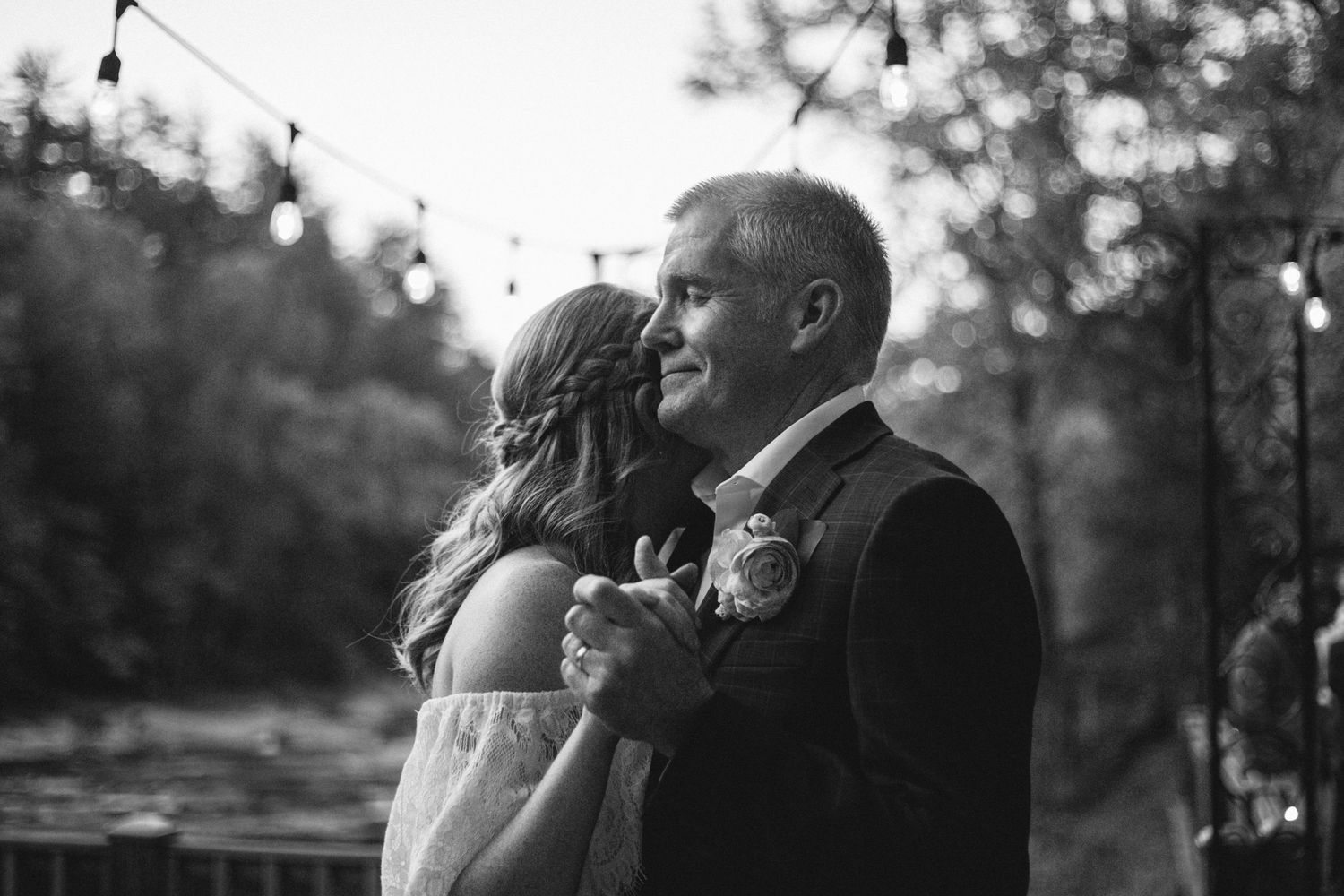 A romantic black and white dance moment under string lights.