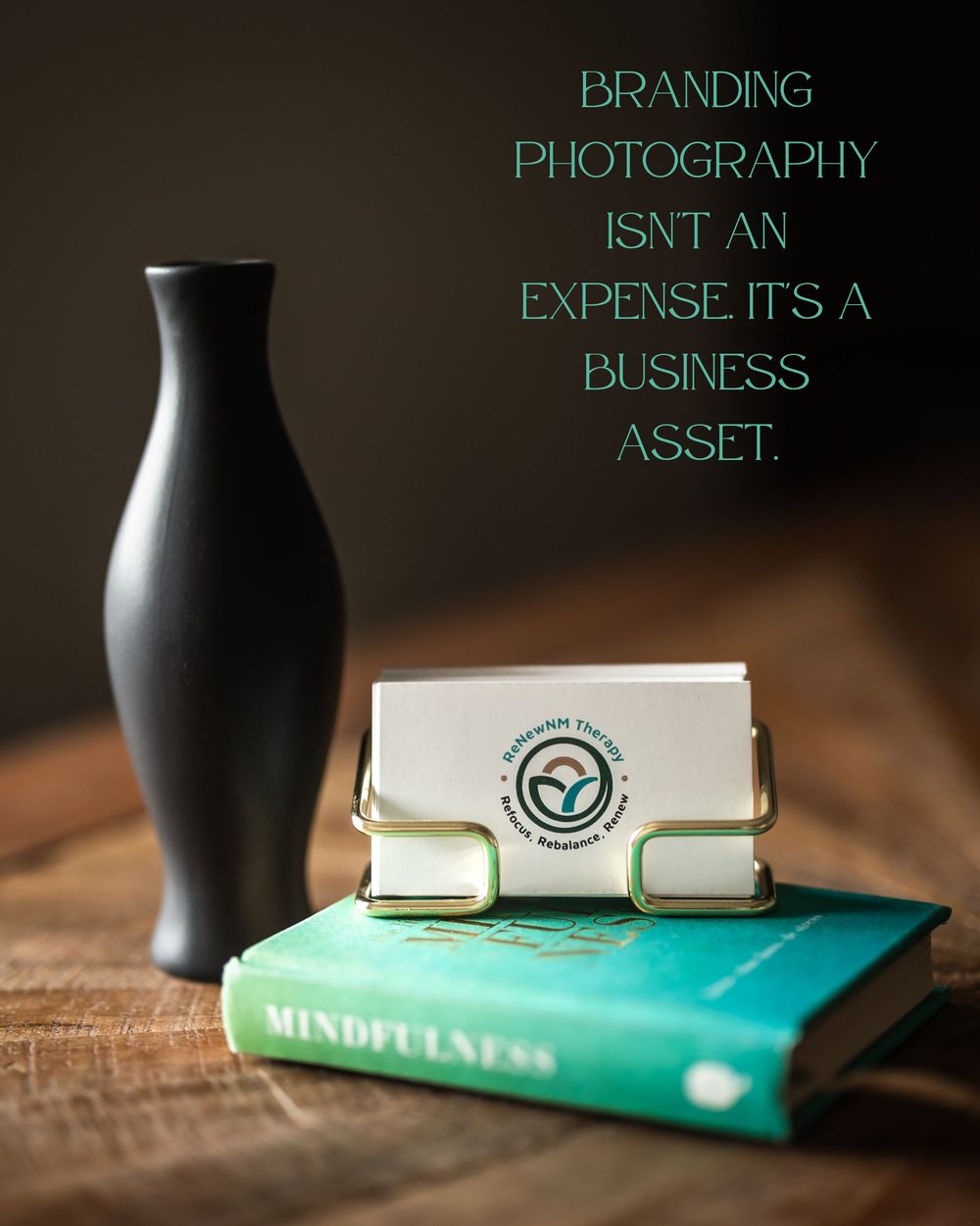 A business card holder on a mindfulness book beside a black vase, with text reading branding photography is a business asset.