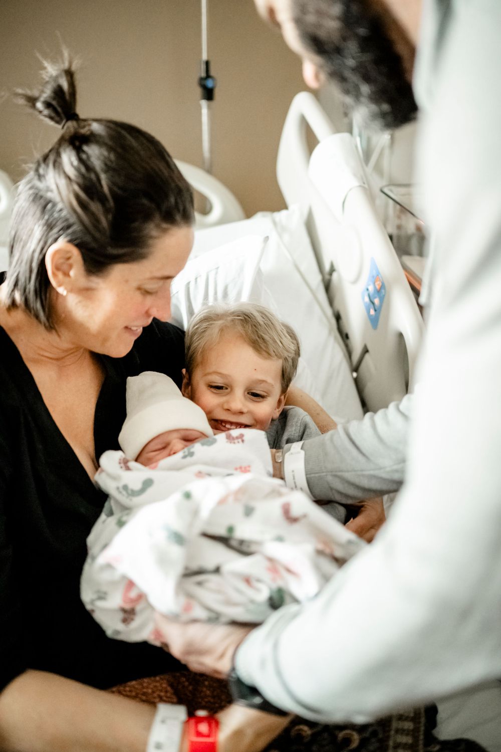 Sweet first moments with a newborn baby in the hospital surrounded by medical staff.