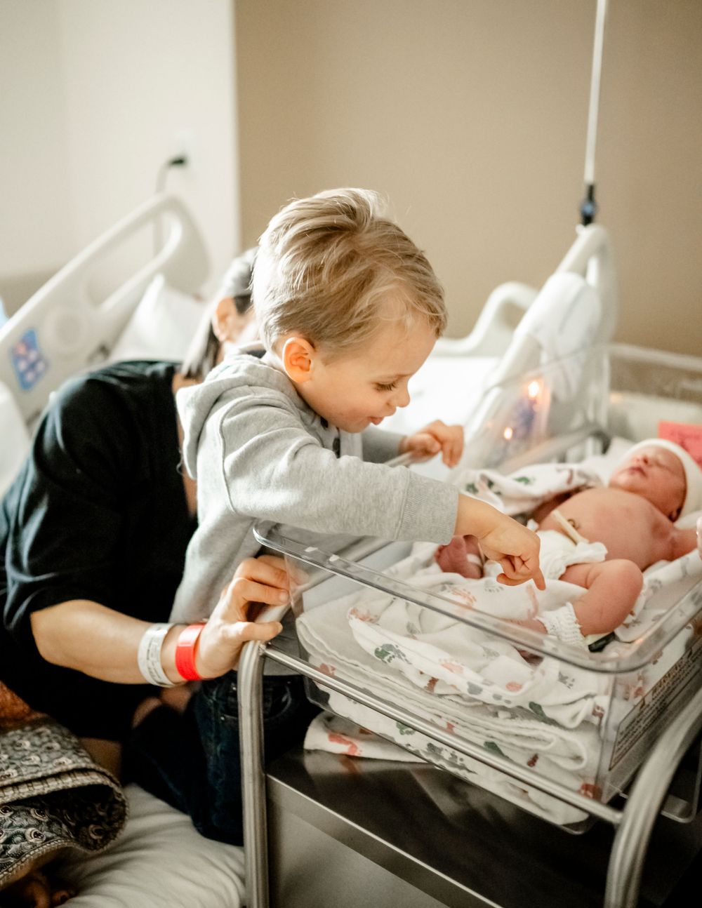 Family bonding with their newborn baby in the hospital nursery.