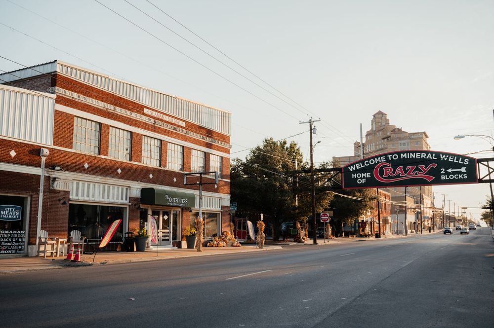 A vintage downtown street scene showing historic brick buildings and storefronts in a small American town.