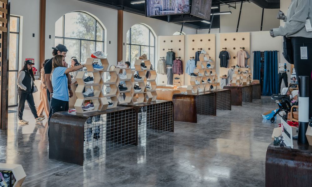 An art gallery displays multiple ceramic busts and sculptures lined up on pedestals inside an elegant room with arched windows.