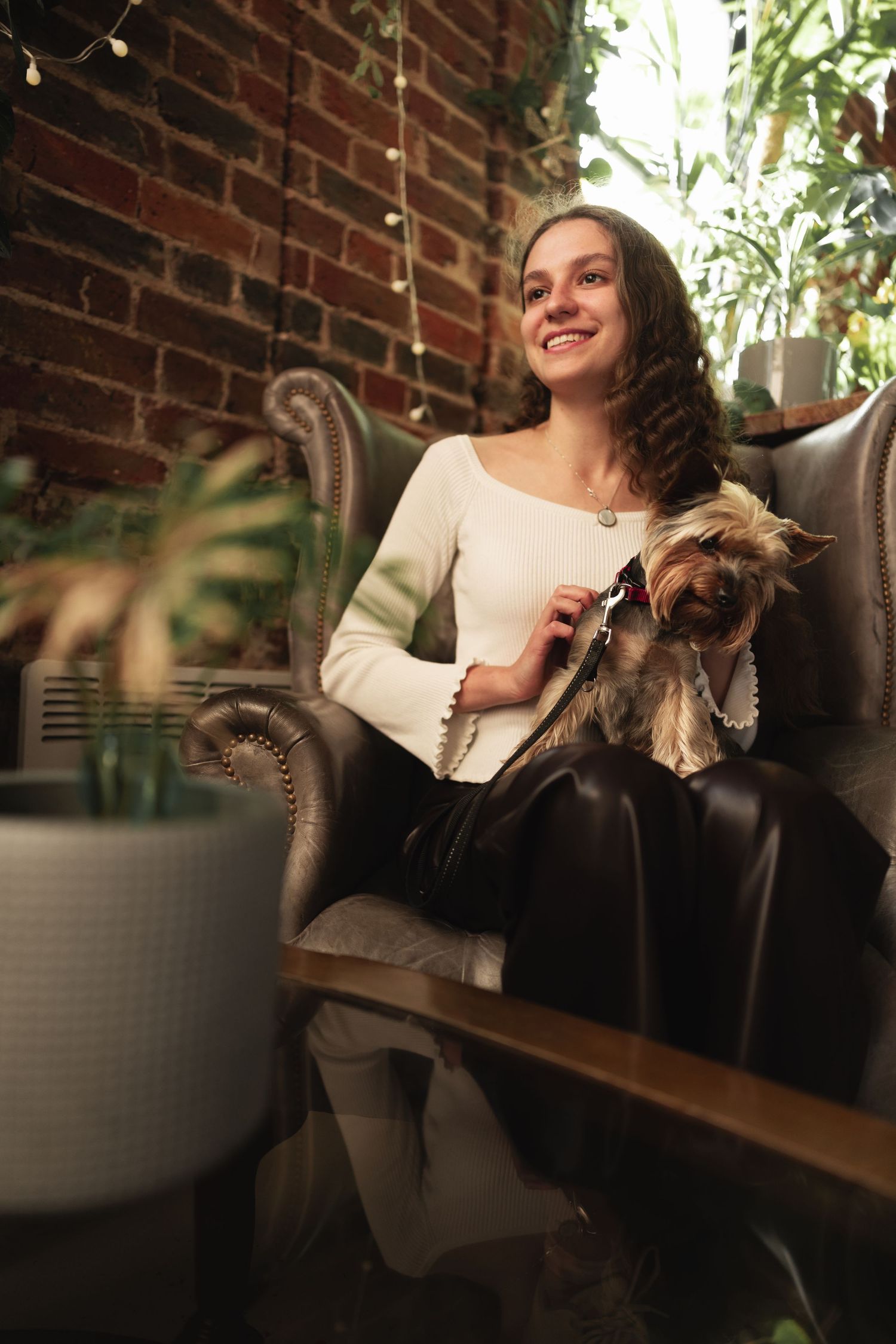 Woman holding a Yorkshire Terrier in a leather armchair at Mettricks coffee house Southampton, lifestyle portrait photography