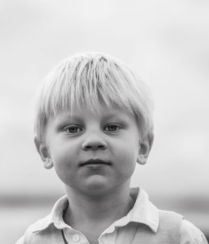 Black and white portrait series showing different expressions and angles of a young child with light hair.