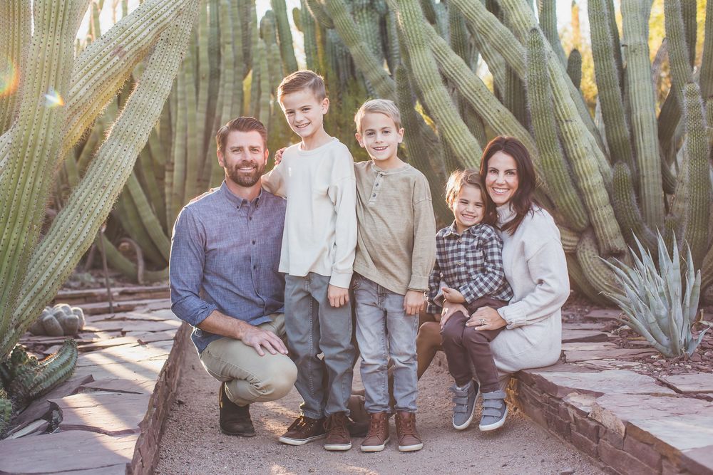 Desert botanical garden family portrait session among saguaro cacti at sunset.