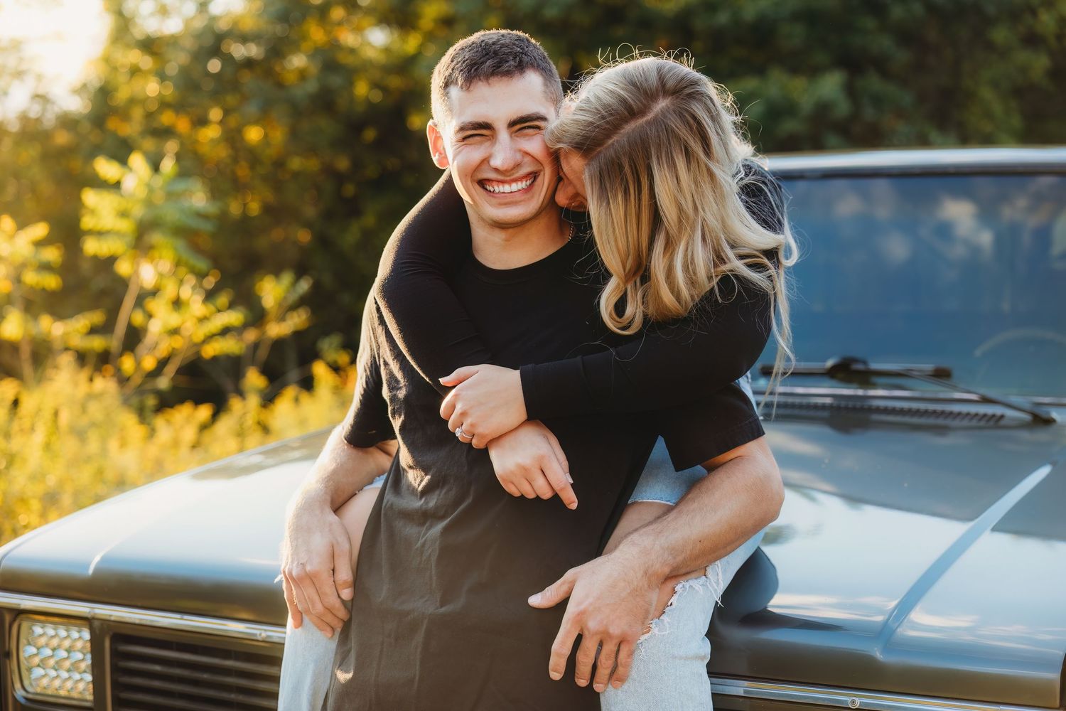 Romantic couple sharing intimate moment in golden sunset light outdoors.